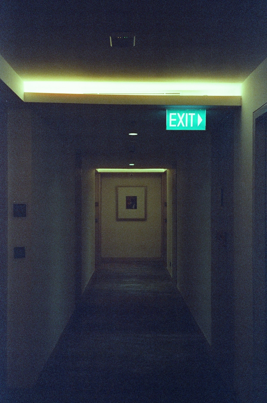 Illuminated Exit Through Dark Corridor
